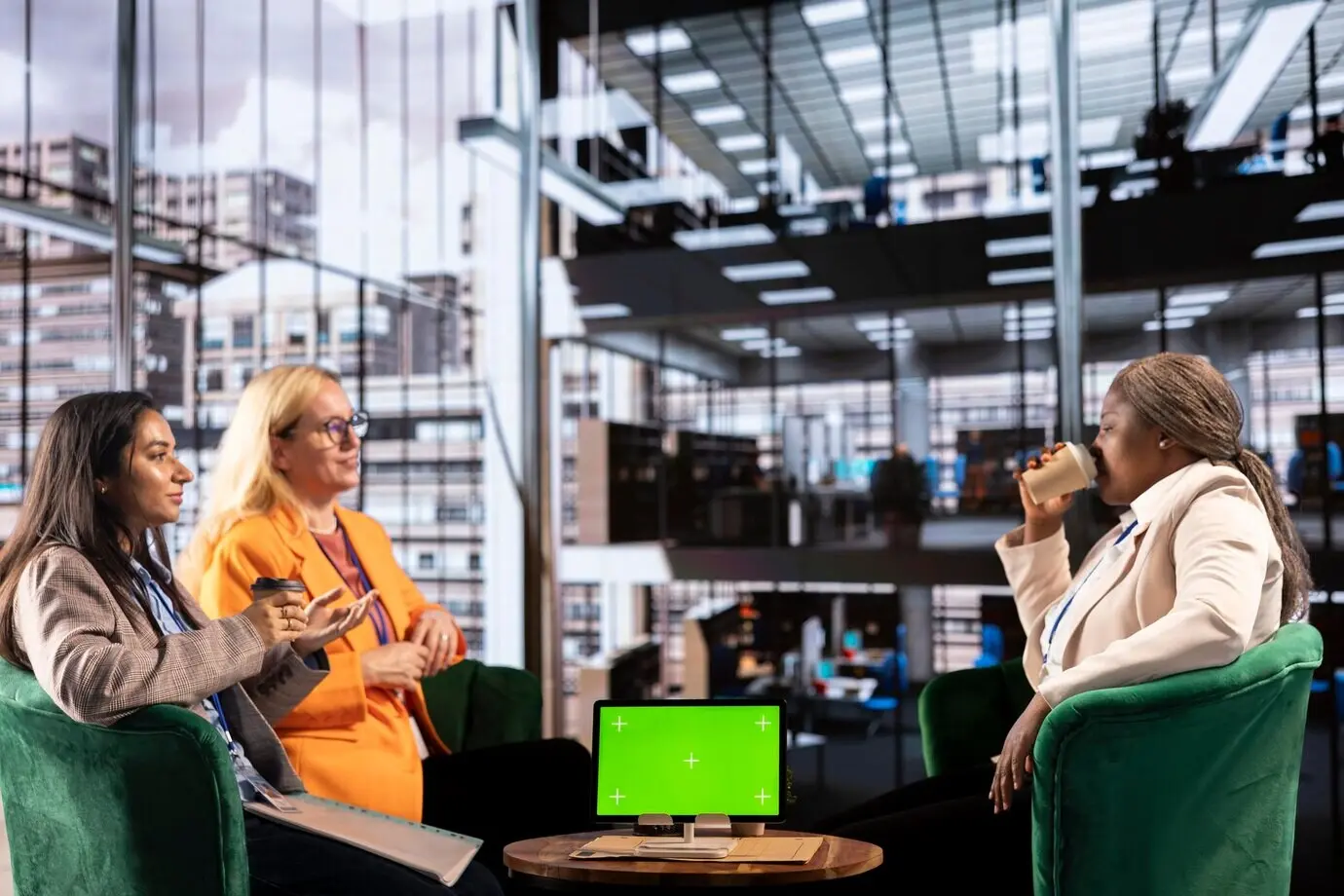 Vielfältige Gruppe weiblicher Kolleginnen, die neben einem Chroma-Key die Zielerreichung sicherstellt.