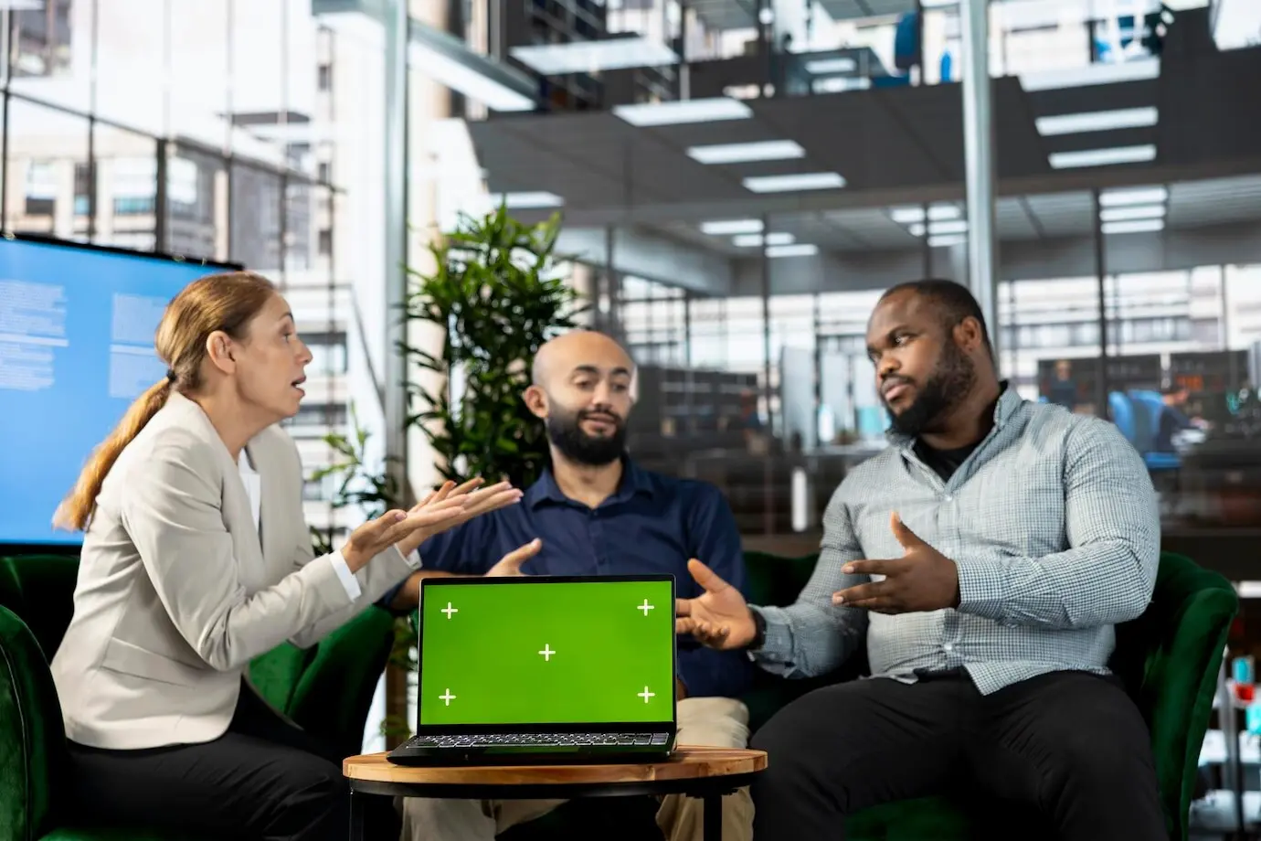 Freigestelltes Tablet mit Bildschirm neben Mitarbeitern, die Forschungsunterlagen durchsehen.