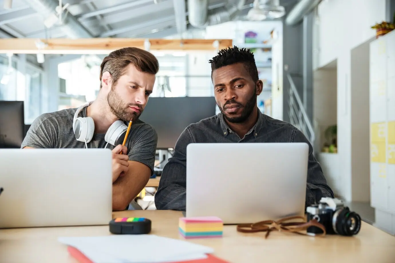 Junge Kollegen sitzen konzentriert im Coworking-Büro.